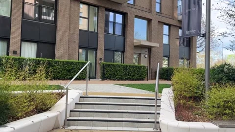 Exiting a modern luxury flat development in the UK - gimbal walk Stock Footage 332553474
