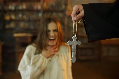 Exorcist casting out devil from scary woman Stock Photos