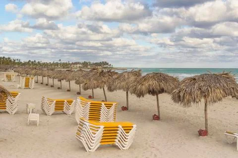 Exotic beach at the end of the day with deck chairs Stock Photos