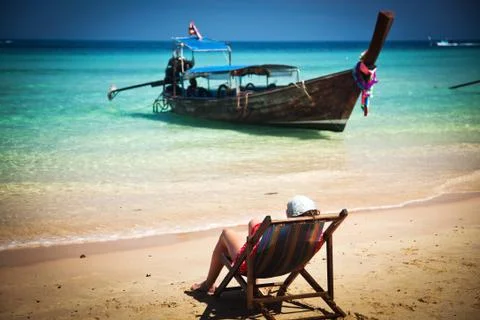 Exotic beach holiday background with beach chair and long tail boat - Thailan Stock Photos