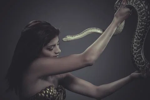 Exotic, brunette woman posing with a python snake australian Foto stock