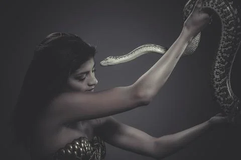 Exotic, brunette woman posing with a python snake australian Stock Photos