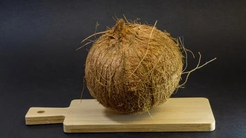Exotic fruit coconut, fruit in the shell on a wooden board, dark background Stock Photos