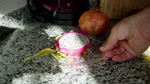 Exotic fruit pitahaya is placed on table on plate in rays of setting sun. dragon Stock Footage 222425976