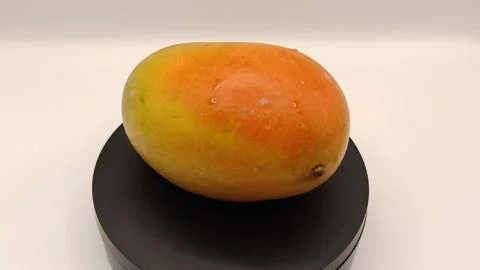 Exotic mango spins on a stand Video stock 325050925