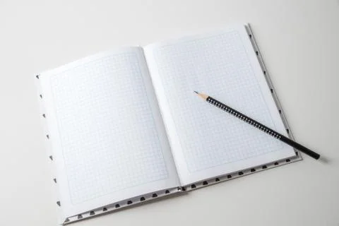 Expanded checkered notebook with open sheets and pencil. Selective focus. Blu Foto stock