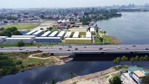 Expansive aerial view captures modular buildings, highway, water, and cityscape Stock Footage 316190749