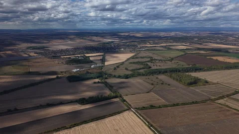 An expansive aerial view captures a patchwork of agricultural fields and a Stock Footage 347822414