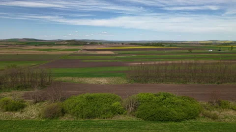 An expansive aerial view captures a vibrant patchwork of agricultural fields Video stock 334268974