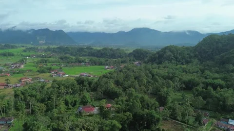 Expansive aerial view of emerald valleys and verdant peaks cradling seclude.. Stock Footage 337277311