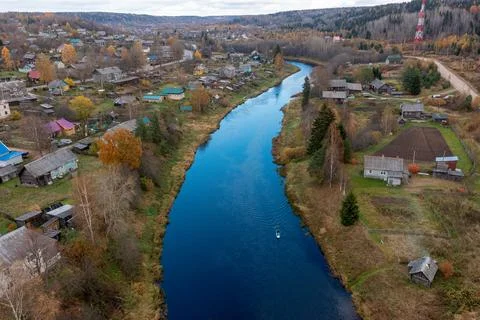 Expansive aerial view looking down a river with a paddleboarder, surrounded by Stock Photos