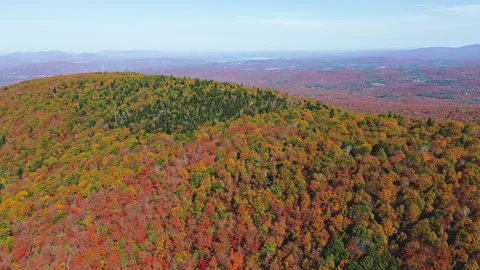 Expansive aerial view of Mount Sutton with red maple autumn landscape in Quebec Stock Footage 318551356