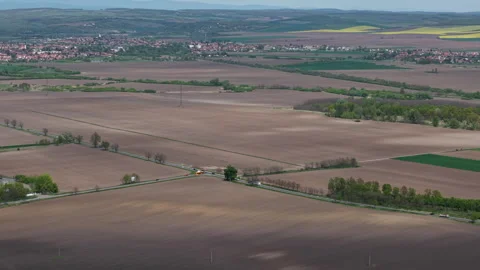 An expansive aerial view reveals vast cultivated fields stretching towards a Video stock 334313065