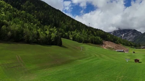 Expansive Alpine Meadow Slopes Framed by Mountain Forests and Sky Stock Footage 342902035
