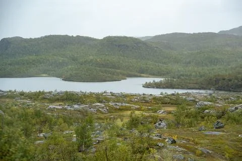 An expansive and tranquil panoramic view of a beautiful Nordic lake nestled w Stock Photos