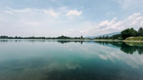 Expansive and Tranquil Panoramic View of a Calm Turquoise Lake Under a Softly Cl Stock-Fotos