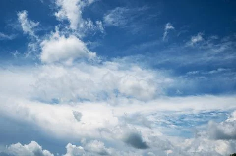 Expansive blue sky with dramatic layered white cloud formations Stock Photos
