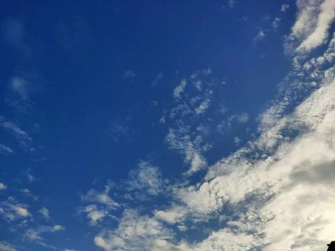 Expansive Blue Sky with Drifting Clouds Stock Photos