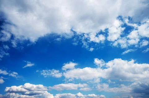 Expansive blue sky with scattered clouds and light Stock Photos