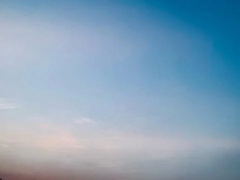 Expansive Blue Sky With Soft Cloud Haze and Luminous Atmospheric Horizon Stock Photos