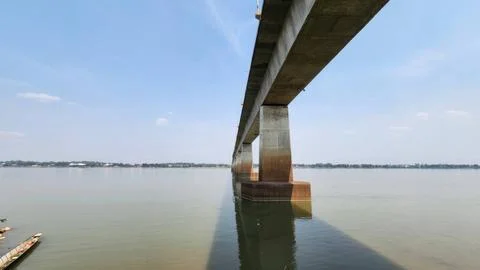Expansive Bridge Structure Over Calm Water Under Clear Blue Sky Stock Photos