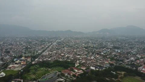Expansive cityscape view with distant mountains under overcast sky providing Stock Photos