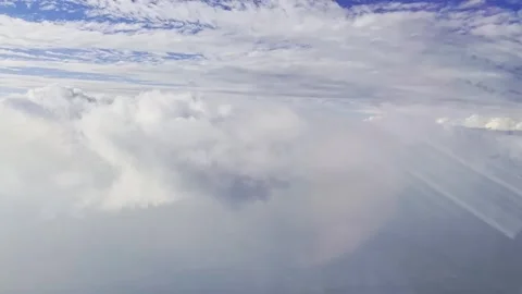 Expansive cloudscape above bright white cloud layer with blue sky and soft Stock Footage 345437333