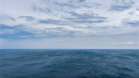 Expansive cloudy sky over sea horizon with subtle wind patterns on water Stock Footage 317626253