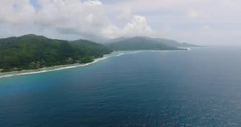 Expansive coastline with distant hills and blue waters. Seychelles, Mahe. Stock Footage 318692089