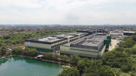 Expansive Data Center Complex Beside a Large Lake Surrounded by Trees at Day Stock Footage 339645377