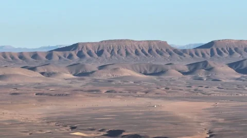 Expansive Desert Landscape with Eroded Plateaus and Rolling Hills Stock Footage 336381048