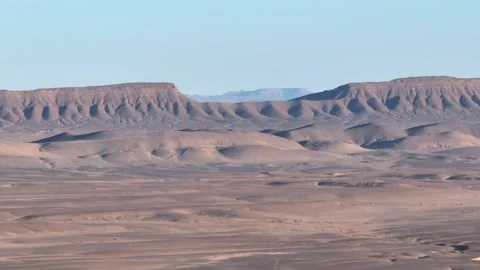 Expansive Desert Landscape with Eroded Plateaus and Rolling Hills Stock Footage 336381051