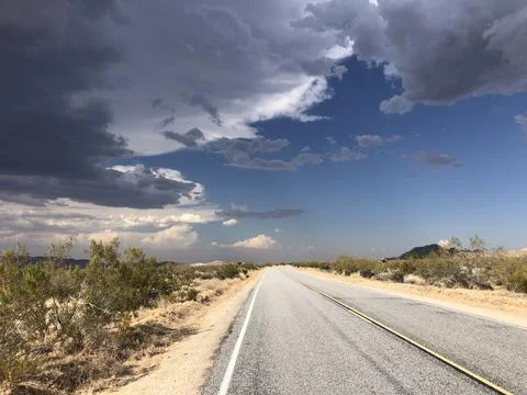 Expansive Desert Road Under Dramatic Skies in the Late Afternoon Stock Photos