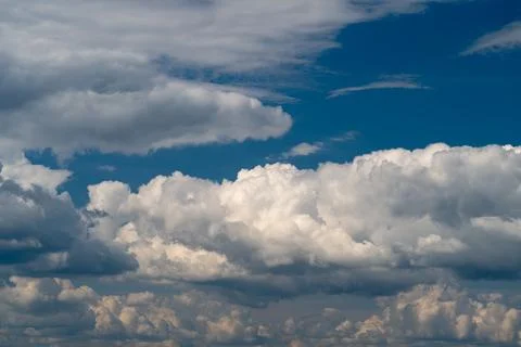 Expansive dramatic cumulus clouds under deep blue sky Stock Photos