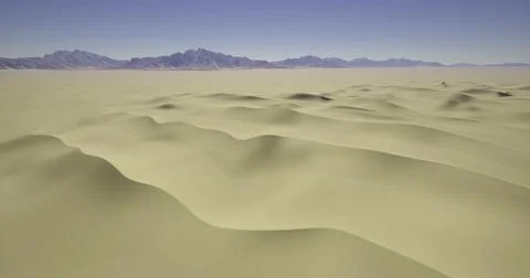 Expansive dunes stretch endlessly across the desert landscape under clear ski Stock Illustration