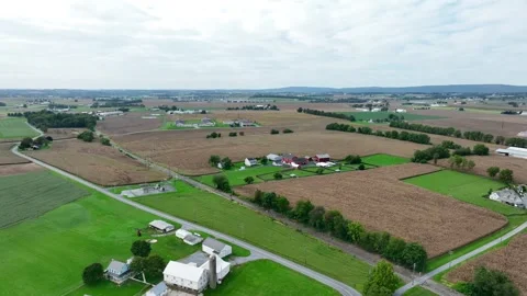 Expansive farmland with patchwork fields and farmhouses from an aerial Stock Footage 255653484
