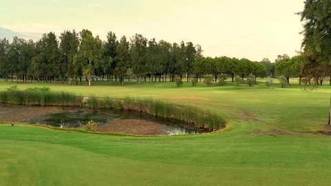 Expansive golf course amidst natural surroundings captured by drone Stock Footage 302279662