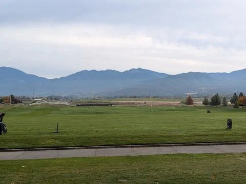 An expansive golf driving range with long green stretches and tee markers Stock Photos