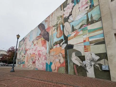 Expansive graffiti-style mural featuring a bird, flowers, landscape Stock Photos