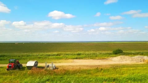 Expansive green and golden fields under a bright blue sky with fluffy clouds Stock Footage 341158556