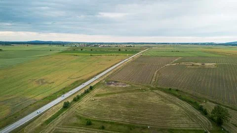 Expansive Green Fields and Highway Stretching Through Rural Landscape Under Stock Photos