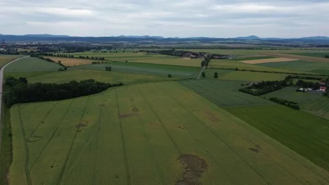 Expansive Green Fields Stretching Through Rural Landscape Under Overcast Sky Stock Footage 280887289