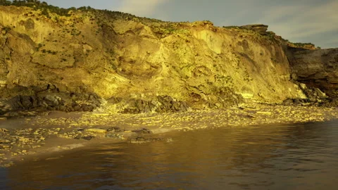 Expansive horizon reveals sunlit cliffs and reflective beaches Stock Footage 342427963