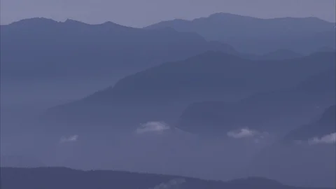 Expansive image of peaks of Mt. Rainier, bathed in a cool blue tint. Stock Footage 86755238