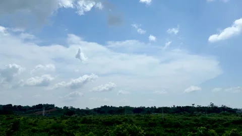 Expansive landscape with lush greenery under a vibrant blue sky dotted with.. Stock Footage 339369046