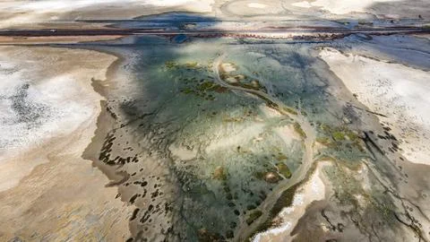 Expansive marshland features meandering streams beautifully flowing under d.. Stock Photos