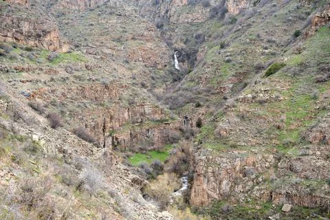 Expansive mountain gorge with subtle waterfall and rocky textures. 库存照片