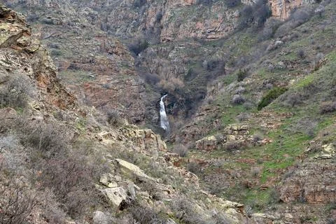 Expansive mountain gorge with subtle waterfall and rocky textures. 스톡 사진
