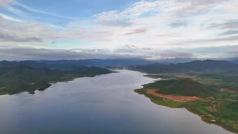Expansive mountain lake under dramatic cloud formations and vivid reflections Stock Footage 317375290