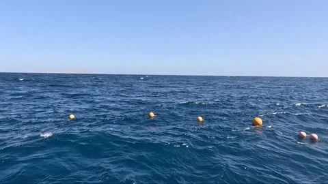 Expansive Ocean View with Floating Buoys Under a Bright Sky; Calm Waters Create Stock-Footage 330183715